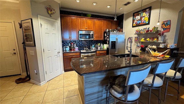 kitchen featuring stainless steel appliances, a sink, crown molding, tasteful backsplash, and a breakfast bar