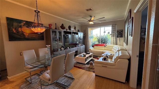 living room featuring wood finished floors, ceiling fan, ornamental molding, and baseboards