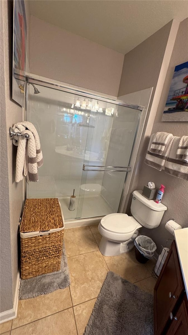 bathroom featuring a stall shower, tile patterned flooring, toilet, and vanity