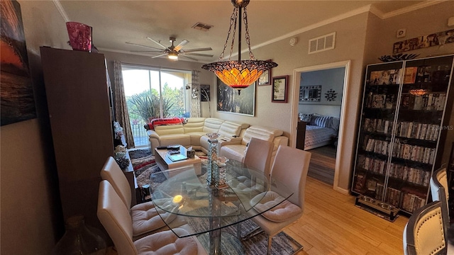 dining area with a ceiling fan, light wood-style floors, and crown molding