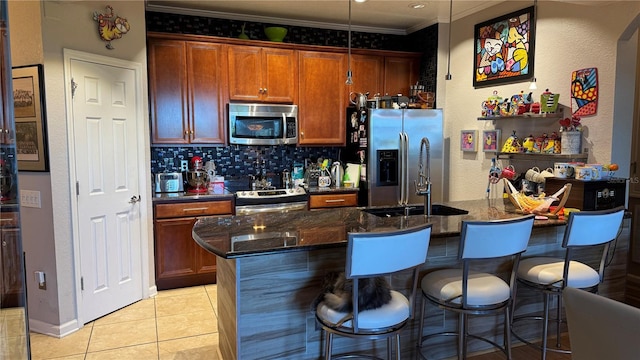 kitchen featuring stainless steel appliances, crown molding, a kitchen breakfast bar, decorative backsplash, and light tile patterned floors