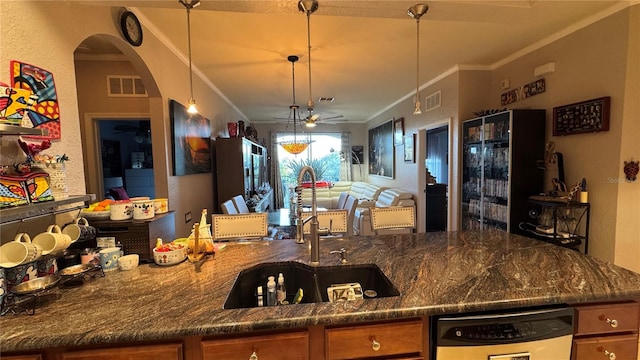 kitchen featuring a sink, dishwasher, ceiling fan, crown molding, and brown cabinets