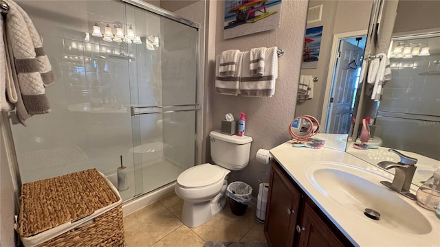 full bathroom with tile patterned flooring, toilet, a shower stall, vanity, and a textured wall