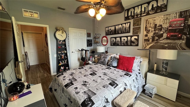 bedroom with wood finished floors, baseboards, and a ceiling fan