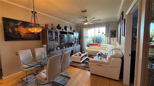living room featuring wood finished floors, ornamental molding, ceiling fan, and baseboards