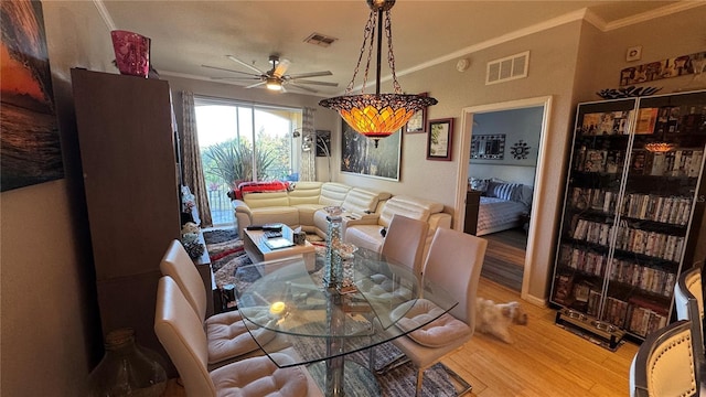 dining area featuring light wood finished floors, crown molding, and ceiling fan