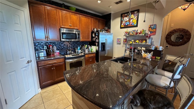 kitchen featuring stainless steel appliances, a sink, backsplash, a breakfast bar, and ornamental molding