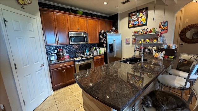 kitchen featuring stainless steel appliances, a sink, a breakfast bar, decorative backsplash, and crown molding