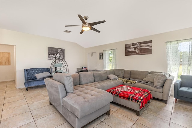 living area featuring lofted ceiling, light tile patterned flooring, and ceiling fan