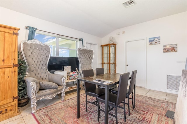 dining room with light tile patterned floors and vaulted ceiling