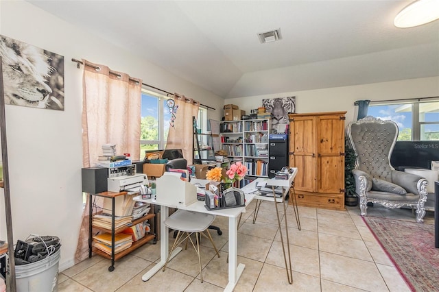 office area with healthy amount of natural light, lofted ceiling, and light tile patterned floors