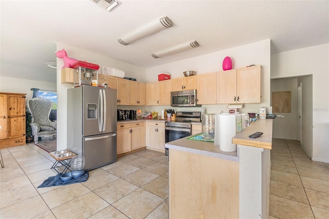 kitchen featuring appliances with stainless steel finishes, light brown cabinets, and light tile patterned floors