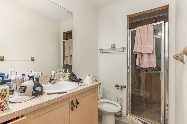 bathroom featuring a stall shower, toilet, and vanity