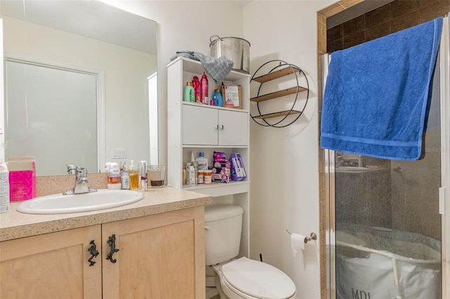 full bathroom featuring a stall shower, toilet, and vanity