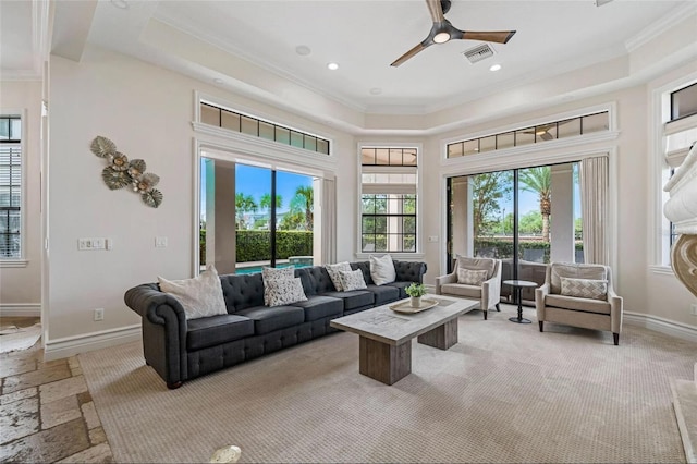 living area with ornamental molding, a raised ceiling, a ceiling fan, baseboards, and recessed lighting
