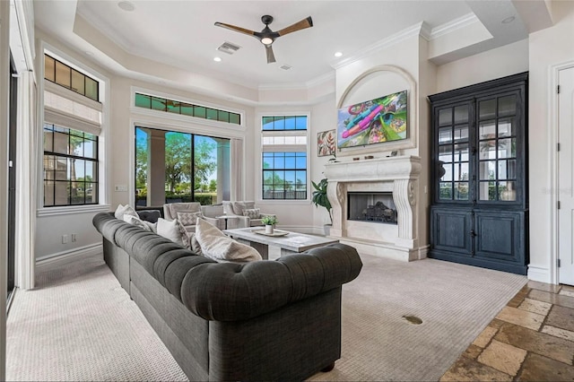 living room featuring ceiling fan, a fireplace, crown molding, stone tile floors, and recessed lighting