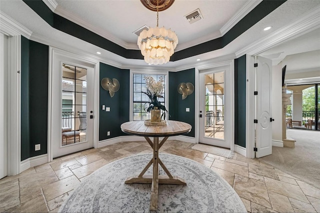 entryway featuring plenty of natural light, stone tile flooring, a chandelier, and crown molding