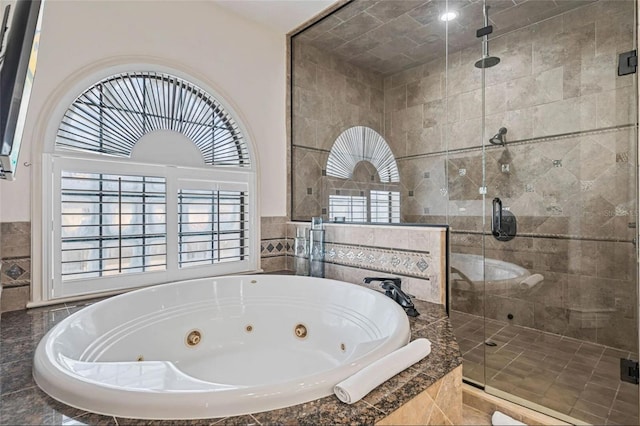 full bath with a whirlpool tub and a stall shower