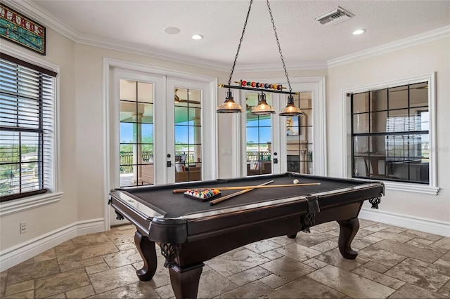 recreation room with stone tile floors, baseboards, healthy amount of natural light, french doors, and ornamental molding