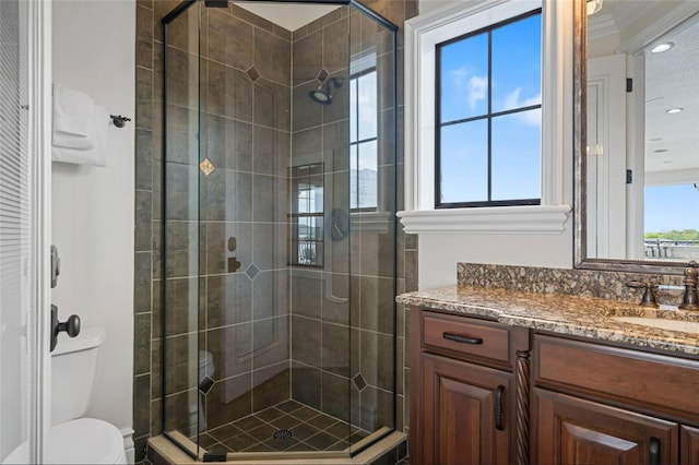 bathroom with a shower stall, toilet, vanity, and recessed lighting