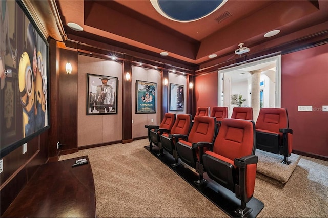 carpeted cinema featuring decorative columns, a raised ceiling, and baseboards
