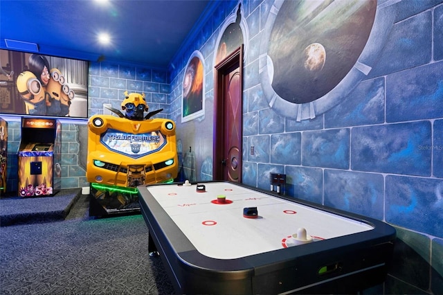 recreation room featuring carpet floors and tile walls