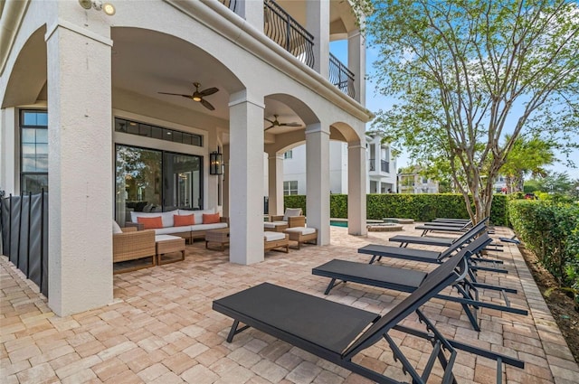 view of patio featuring an outdoor hangout area, ceiling fan, and a balcony