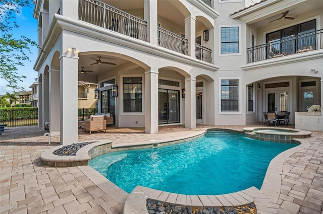 view of pool featuring a patio area, ceiling fan, fence, and a pool with connected hot tub