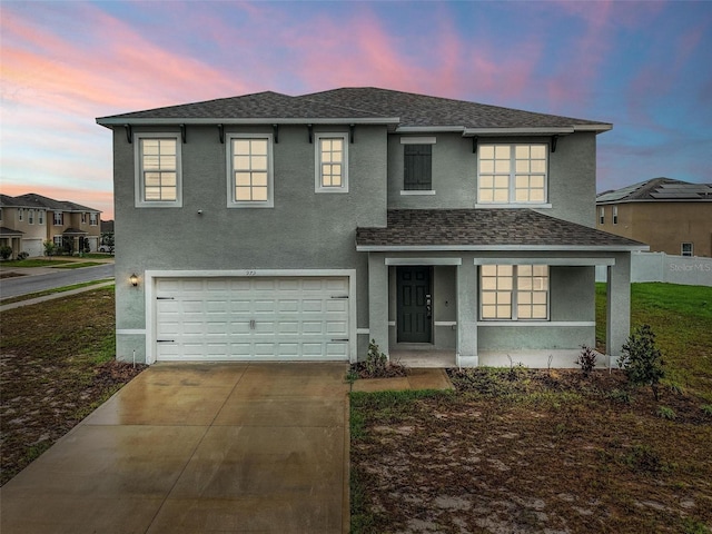 979 Sun Burst Rd, Winter Haven, FL 33880 - traditional-style home with stucco siding, an attached garage, concrete driveway, roof with shingles, and covered porch