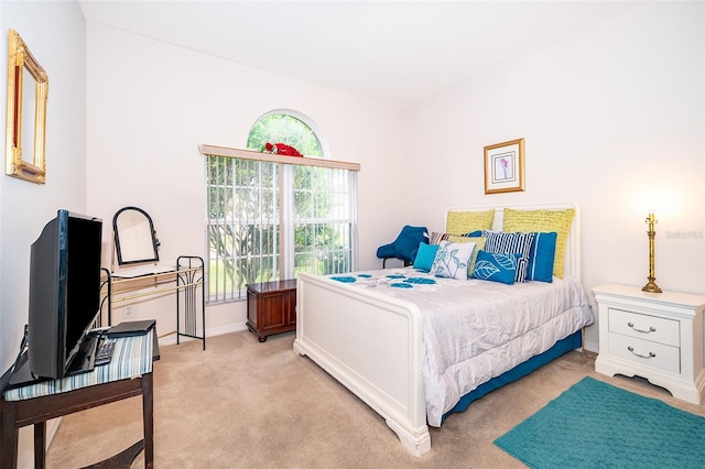 bedroom featuring light carpet and baseboards