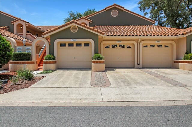 7858 Sugar View Ct Unit 7858, Orlando, FL 32819 - mediterranean / spanish home with stucco siding, a tile roof, driveway, and a garage