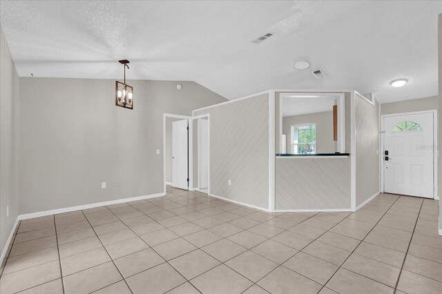 3685 Sunday Dr, Deltona, FL 32738 - spare room with vaulted ceiling, a chandelier, light tile patterned flooring, a textured ceiling, and baseboards