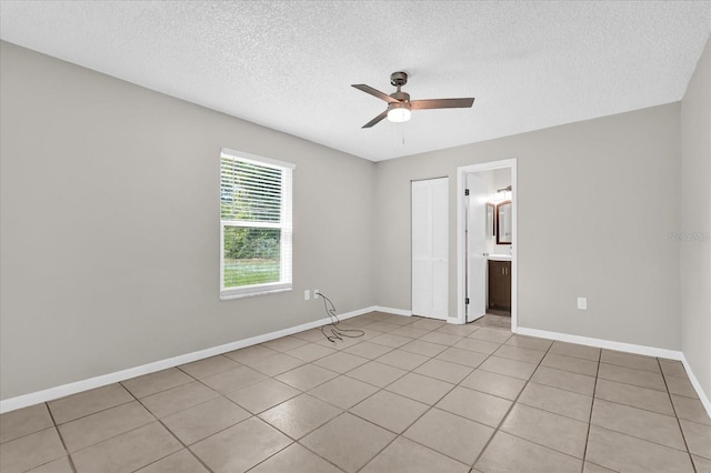 3685 Sunday Dr, Deltona, FL 32738 - spare room featuring ceiling fan, a textured ceiling, baseboards, and light tile patterned floors