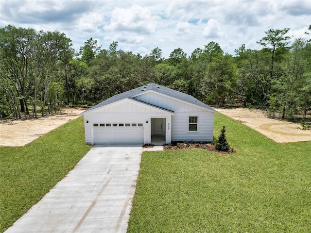 8258 SW 136th Ter, Dunnellon, FL 34432 - view of front of property featuring driveway, a front lawn, an attached garage, and board and batten siding