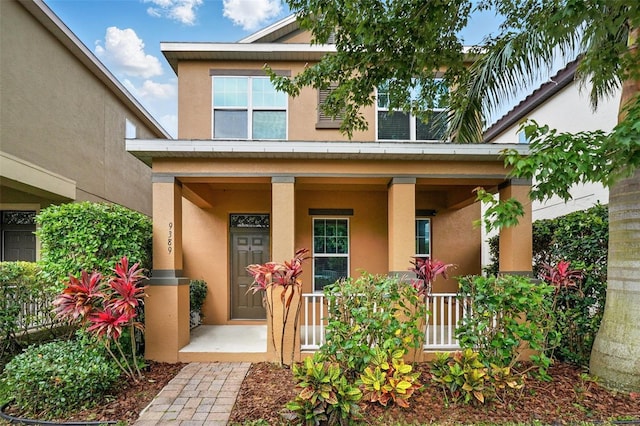 doorway to property with stucco siding and covered porch