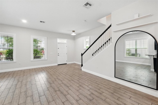 entrance foyer with stairway, wood finished floors, and baseboards