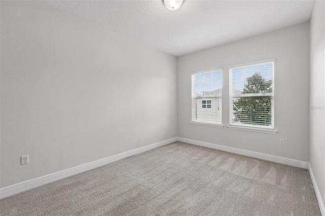 empty room featuring carpet flooring and baseboards