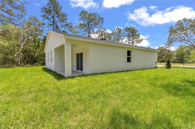13101 SW 85th Pl, Dunnellon, FL 34432 - view of property exterior featuring stucco siding and a lawn