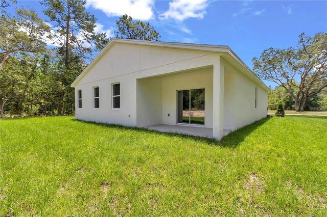 13101 SW 85th Pl, Dunnellon, FL 34432 - rear view of house featuring a yard, stucco siding, and a patio area