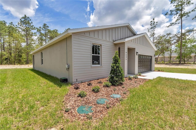 9695 SW 125 Court Rd, Dunnellon, FL 34432 - view of home's exterior featuring board and batten siding, a lawn, an attached garage, and concrete driveway