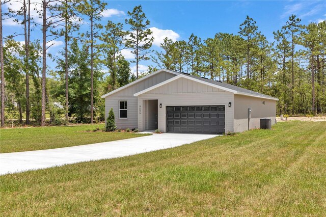 9695 SW 125 Court Rd, Dunnellon, FL 34432 - view of front of house with a front lawn, a garage, concrete driveway, and central AC unit