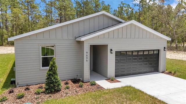 9695 SW 125 Court Rd, Dunnellon, FL 34432 - view of front of home with board and batten siding, a garage, and driveway