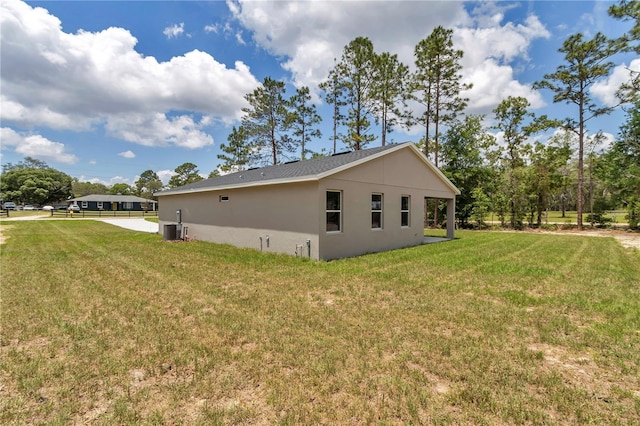 9695 SW 125 Court Rd, Dunnellon, FL 34432 - view of side of home featuring cooling unit, a lawn, and stucco siding