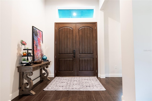 entrance foyer with dark wood-style flooring and baseboards