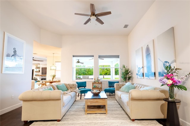 living room featuring a ceiling fan, wood finished floors, and baseboards