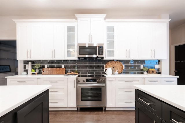 kitchen with appliances with stainless steel finishes, light countertops, and white cabinets