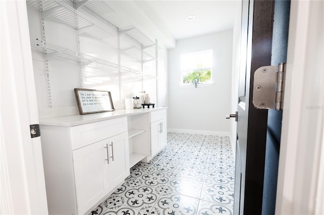 laundry area with baseboards and light floors