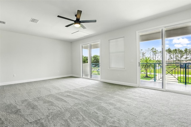 carpeted empty room featuring a ceiling fan and baseboards
