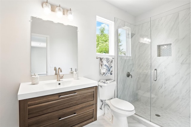 bathroom featuring a marble finish shower, toilet, and vanity