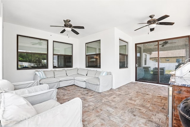 living area featuring ceiling fan and healthy amount of natural light